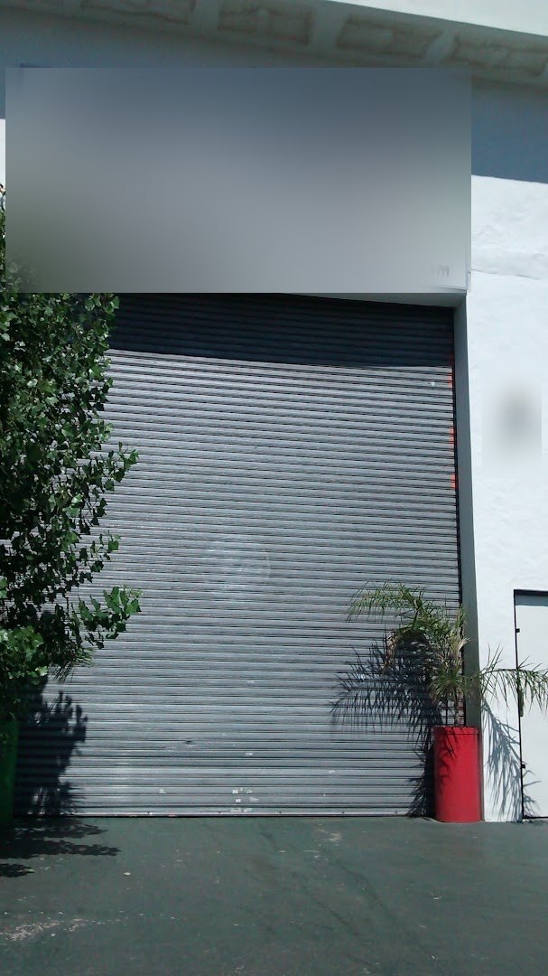 Frente del concesionario Concesionaria en tu zona: portón de chapa gris y el cartel blanco sobre la puerta
