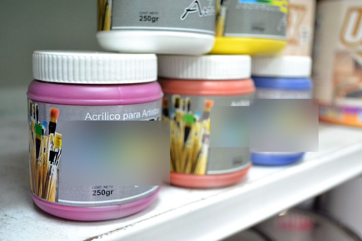 Frascos de pintura acrílica para artistas exhibidos en la góndola de la pinturería, tu zona