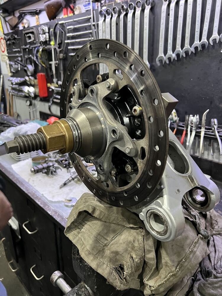 Detalle del disco de freno y el buje de una moto desarmados sobre un paño de trabajo
