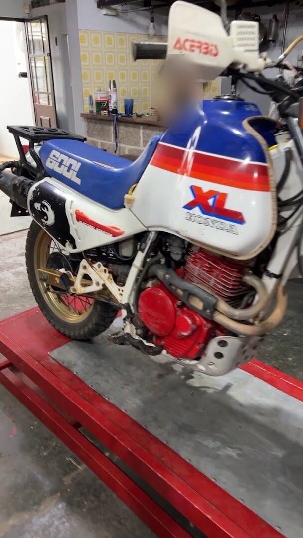 Honda XL600L Paris-Dakar, con la característica librea azul, blanca y roja, en el taller