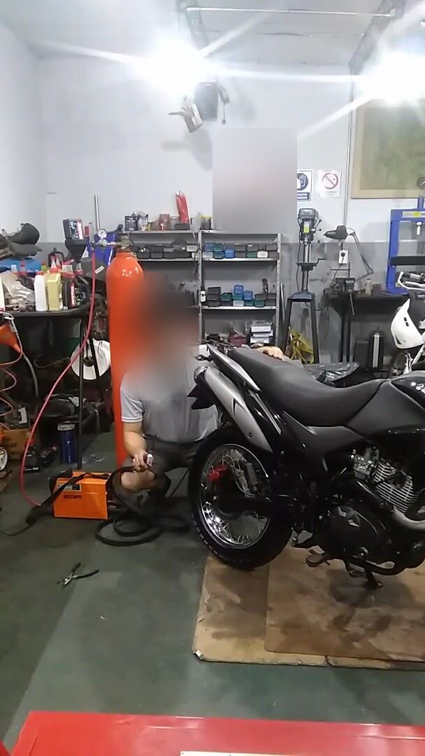 Mecánico del taller soldando la llanta de una rueda en el taller de tu zona