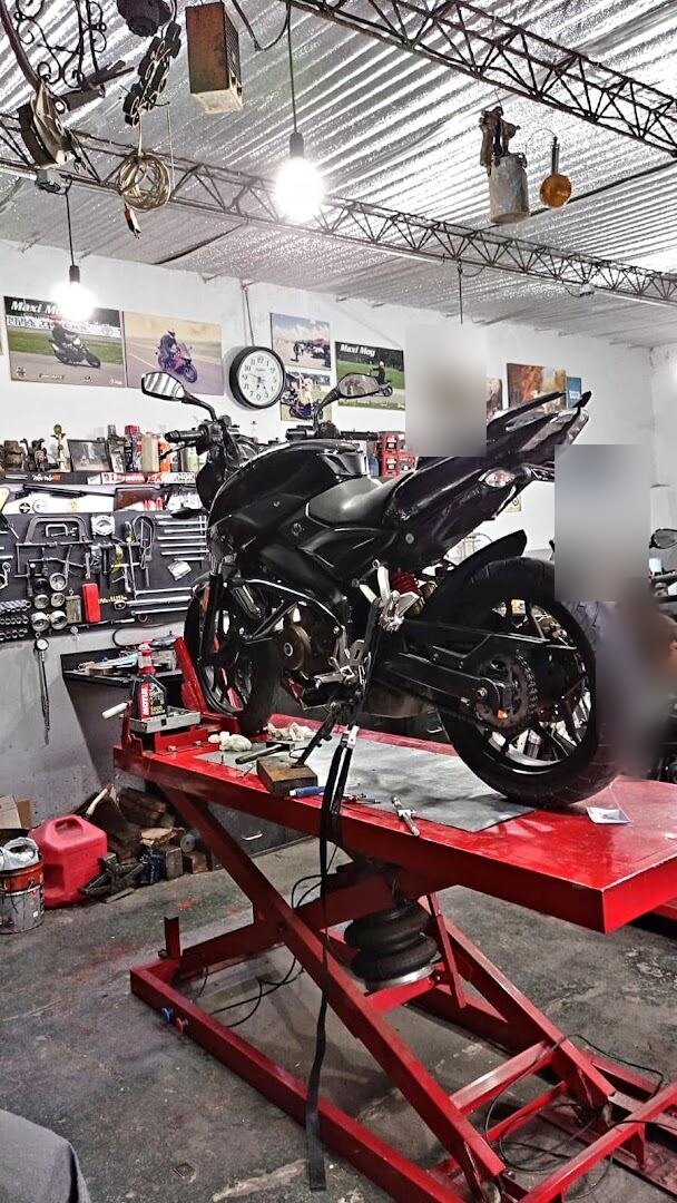 Moto naked negra montada en el elevador del taller, lista para su revisión