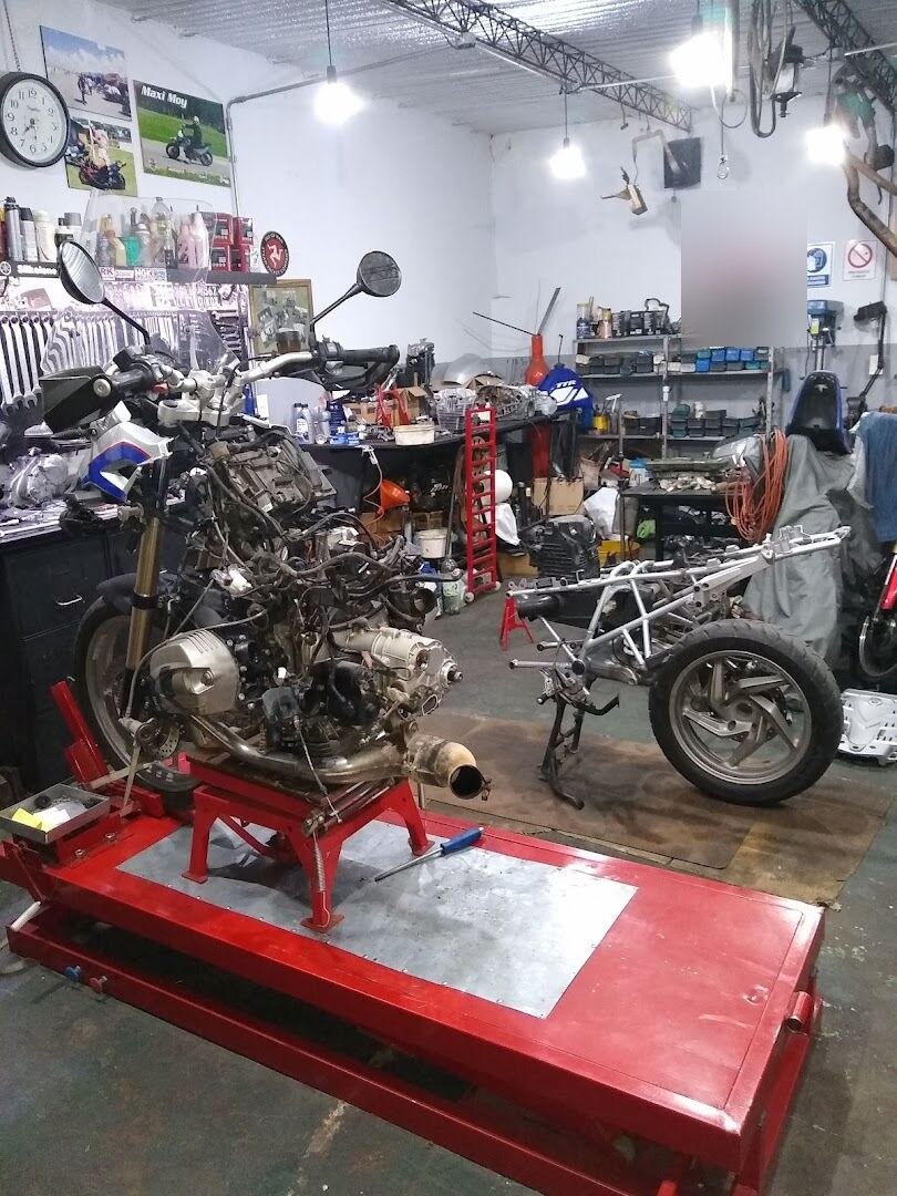 Interior del taller con un motor de moto montado en un elevador para su revisión